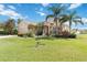 Beautiful home with palm trees and well-manicured lawn and landscaping in front, with a pond in the background at 4262 70Th Street E Cir, Palmetto, FL 34221