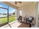 Screened-in lanai with wicker rocking chairs, a view of the pond, and access to the outdoors at 4262 70Th Street E Cir, Palmetto, FL 34221