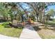 Community playground featuring colorful equipment, surrounded by mature trees and comfortable benches at 4262 70Th Street E Cir, Palmetto, FL 34221