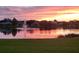 Picturesque pond at sunset with a fountain, trees, and surrounding homes reflecting in the water at 4262 70Th Street E Cir, Palmetto, FL 34221