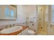Bathroom featuring a glass-enclosed shower, a sink with marble countertop and a window providing natural light at 5024 Commonwealth Dr, Sarasota, FL 34242