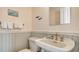 Bathroom featuring decorative wall accents, white wainscotting, and a sink with gold fixtures at 5024 Commonwealth Dr, Sarasota, FL 34242