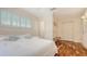 Bedroom with light walls, hardwood floors, windows, closet and a bench for added seating at 5024 Commonwealth Dr, Sarasota, FL 34242