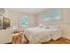 Bedroom with light walls, hardwood floors, TV, and windows allowing natural light to flow through the space at 5024 Commonwealth Dr, Sarasota, FL 34242