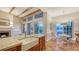 Open kitchen with custom cabinets, farmhouse sink and breakfast nook overlooking scenic backyard and fireplace at 5024 Commonwealth Dr, Sarasota, FL 34242