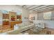 Bright living room featuring exposed wood beams, hardwood floors, and a seamless flow to the kitchen area at 5024 Commonwealth Dr, Sarasota, FL 34242