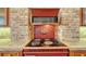 Close up of a vintage range oven surrounded by custom wood cabinetry, a brick arch and tile countertops at 5024 Commonwealth Dr, Sarasota, FL 34242