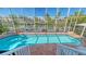 Sparkling screened-in pool with brick accents overlooking the waterfront canal and neighboring houses at 5024 Commonwealth Dr, Sarasota, FL 34242