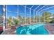 Beautiful screened-in pool surrounded by lush landscaping and scenic waterway views at 5024 Commonwealth Dr, Sarasota, FL 34242
