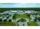 An aerial view of a school with modern architecture, surrounded by trees, lawns, and parking at 5115 Foxhall Rd, North Port, FL 34288