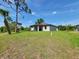 Expansive backyard featuring a well-maintained lawn and partial view of the back of a home under a blue sky at 5115 Foxhall Rd, North Port, FL 34288