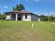 A spacious backyard featuring an exterior patio, lawn with grass and a newly built home at 5115 Foxhall Rd, North Port, FL 34288
