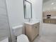 Modern bathroom featuring stylish vanity, toilet and view into kitchen with island at 5115 Foxhall Rd, North Port, FL 34288