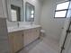 Stylish bathroom with double sink vanity, modern fixtures, and a bright window at 5115 Foxhall Rd, North Port, FL 34288