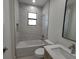 Bathroom features tiled walls, a window, toilet, tub and vanity at 5115 Foxhall Rd, North Port, FL 34288