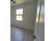 Bright bedroom with white walls, wood-look floors, and a black frame window at 5115 Foxhall Rd, North Port, FL 34288