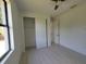 Bright bedroom with white walls, wood-look floors, ceiling fan, closet and window at 5115 Foxhall Rd, North Port, FL 34288