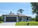 Single-story home with a two-car garage and well-maintained lawn at 5115 Foxhall Rd, North Port, FL 34288