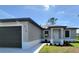 The front exterior features neutral paint, a well kept lawn and tidy flower beds at 5115 Foxhall Rd, North Port, FL 34288