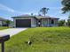 Charming single-story home featuring a two-car garage and lush green lawn at 5115 Foxhall Rd, North Port, FL 34288