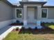 Inviting front porch with manicured landscaping and a freshly painted door at 5115 Foxhall Rd, North Port, FL 34288