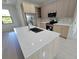 Modern kitchen with stainless steel appliances, stone countertops, and island sink at 5115 Foxhall Rd, North Port, FL 34288