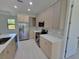 Modern kitchen boasts stainless steel appliances, quartz countertops, light wood cabinets, and sleek tile backsplash at 5115 Foxhall Rd, North Port, FL 34288