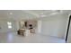 Bright open-concept living room with sleek flooring connects to a modern kitchen featuring an island and stainless appliances at 5115 Foxhall Rd, North Port, FL 34288