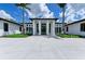 Modern white building with palm trees, black-framed windows and entryway, and manicured landscaping at 5122 Marsh Field Rd # 62, Sarasota, FL 34235