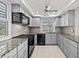 Bright kitchen with gray cabinets, granite counters, tile backsplash, and black appliances at 5122 Marsh Field Rd # 62, Sarasota, FL 34235