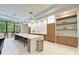 Spacious kitchen featuring a large island, bar stools, and custom wood shelving with lighting at 5122 Marsh Field Rd # 62, Sarasota, FL 34235