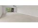 Spacious living room with neutral carpet and a sliding glass door leading to the balcony at 5122 Marsh Field Rd # 62, Sarasota, FL 34235