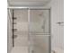 Enclosed shower with sliding glass doors and sleek fixtures and basket storage at 5122 Marsh Field Rd # 62, Sarasota, FL 34235