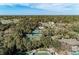 Aerial view of tennis courts surrounded by lush greenery and tall trees at 5122 Marsh Field Rd # 62, Sarasota, FL 34235