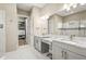 Bathroom featuring double vanities, a large mirror, and access to walk-in closet at 5388 Bartolomeo St, Sarasota, FL 34238