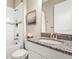 Bathroom featuring granite vanity, toilet and shower over tub combo with tiled walls at 5388 Bartolomeo St, Sarasota, FL 34238