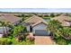 Beautiful single-Gathering home featuring a tile roof, two-car garage, brick paver driveway, and lush landscaping at 5388 Bartolomeo St, Sarasota, FL 34238