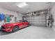 Well-organized garage with storage solutions and a sleek red car, perfect for car enthusiasts and hobbyists at 5388 Bartolomeo St, Sarasota, FL 34238