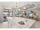 Island kitchen with stone countertops, undermount sink, and views of backyard patio at 5388 Bartolomeo St, Sarasota, FL 34238