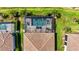 Aerial view of a screened pool with brick paver patio and lounge chairs, surrounded by tropical landscaping at 5388 Bartolomeo St, Sarasota, FL 34238