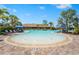 Large community pool with shallow wading area, palm trees, and plenty of lounge chairs at 5388 Bartolomeo St, Sarasota, FL 34238