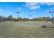 Community tennis court featuring green surface, lighting, and adjacent seating at 5388 Bartolomeo St, Sarasota, FL 34238