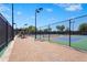 Outdoor tennis courts with fencing, lighting, and paved walkways on a sunny day at 5388 Bartolomeo St, Sarasota, FL 34238