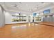 Bright yoga studio with hardwood floors, ceiling fans, wall of windows and mirrored wall at 5388 Bartolomeo St, Sarasota, FL 34238