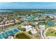 Wide aerial view showing the residential buildings, tennis courts, and waterfront setting at 5631 Midnight Pass Rd # 1007, Sarasota, FL 34242