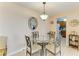 Cozy dining area features a glass table, four chairs, and decorative mirror at 5631 Midnight Pass Rd # 1007, Sarasota, FL 34242