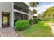 Building exterior with lush landscaping, a paved walkway, and palm trees, in a quiet community at 5631 Midnight Pass Rd # 1007, Sarasota, FL 34242