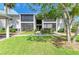 Inviting condo exterior with a well-maintained lawn and mature trees, offering a serene and peaceful setting at 5631 Midnight Pass Rd # 1007, Sarasota, FL 34242