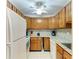 Functional kitchen with wood cabinets, granite countertops, and modern appliances at 5631 Midnight Pass Rd # 1007, Sarasota, FL 34242