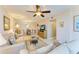 Cozy living room showcasing neutral toned sofas, ceiling fan, and view to dining area at 5631 Midnight Pass Rd # 1007, Sarasota, FL 34242
